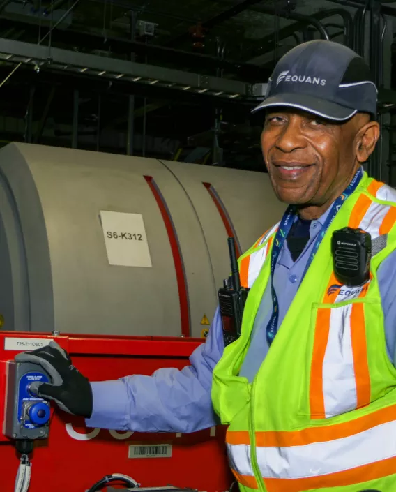 Technician next to a Airport baggage scanner