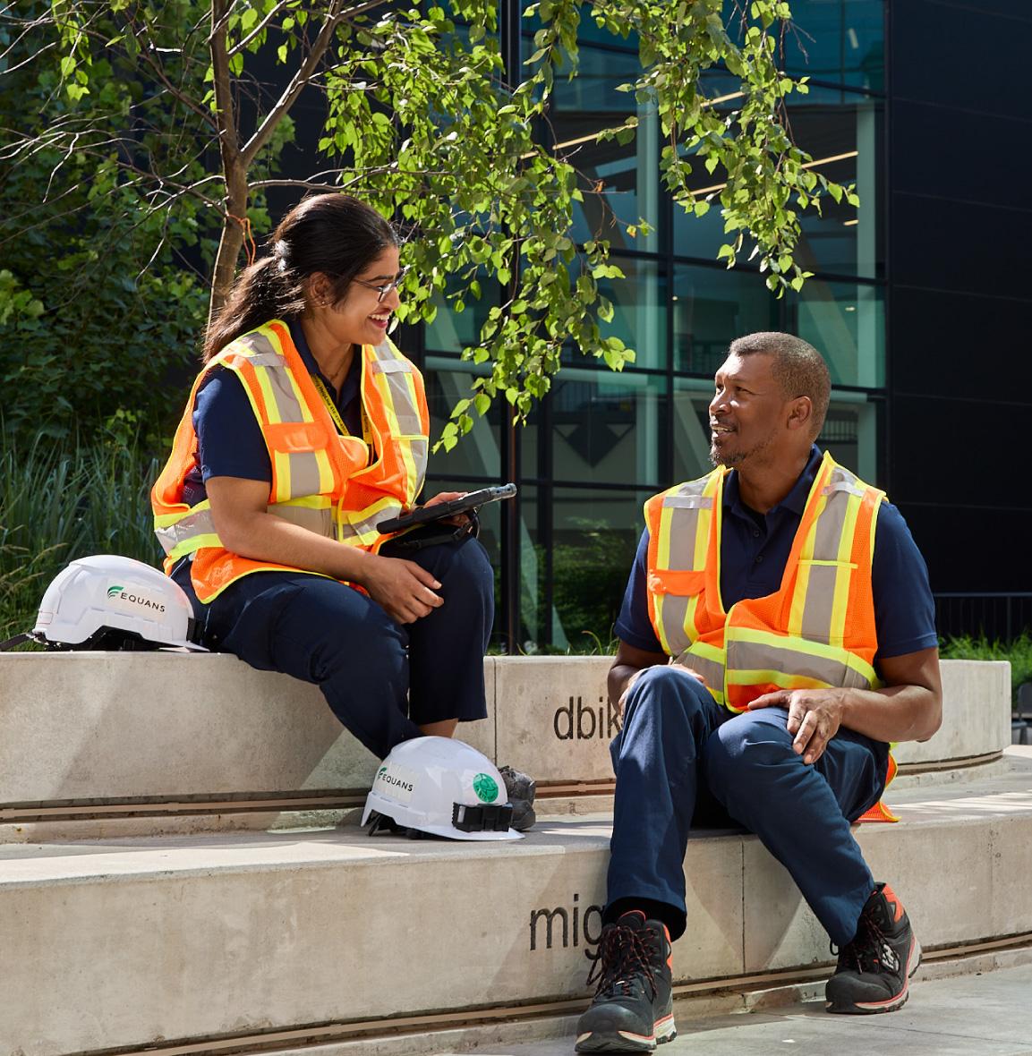 2 persons working outside of a building doing cliamate resilience plan